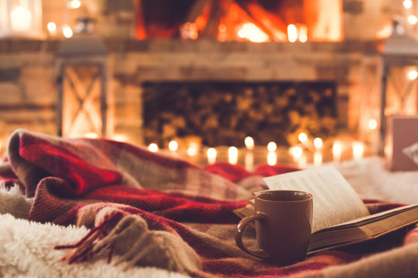 One cup and a book near the fireplace winter concept One cup and a book near the fireplace winter concept